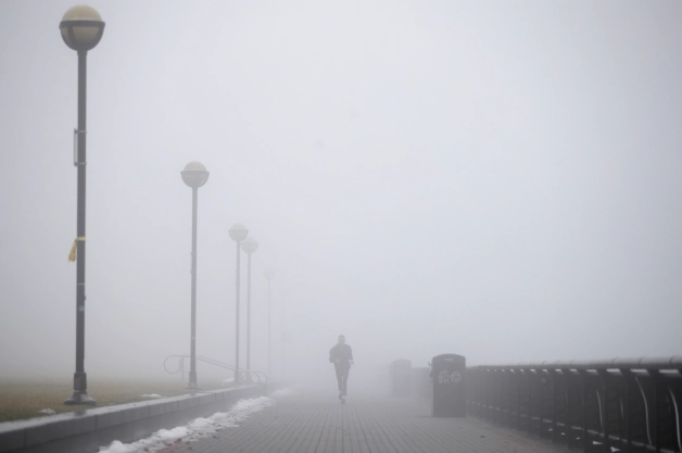 A car driving through dense freezing fog on a highway