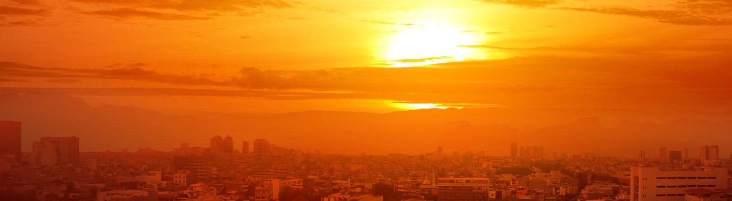 A city skyline under a glaring sun, indicating a heatwave.
