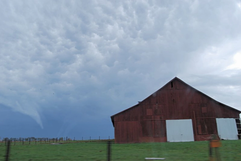 A tornado touching down in a rural landscape