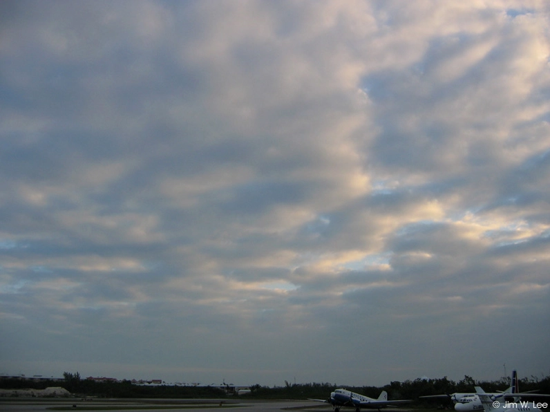 A wide view of stratocumulus clouds spread across the sky in distinct rows.
