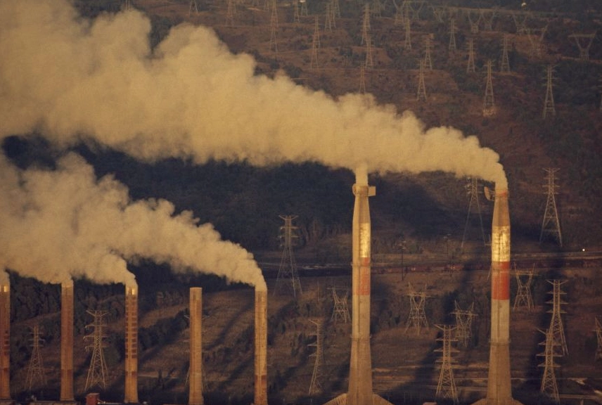 Coal-fueled power plant emitting smoke, symbolizing the burning of fossil fuels contributing to global warming
