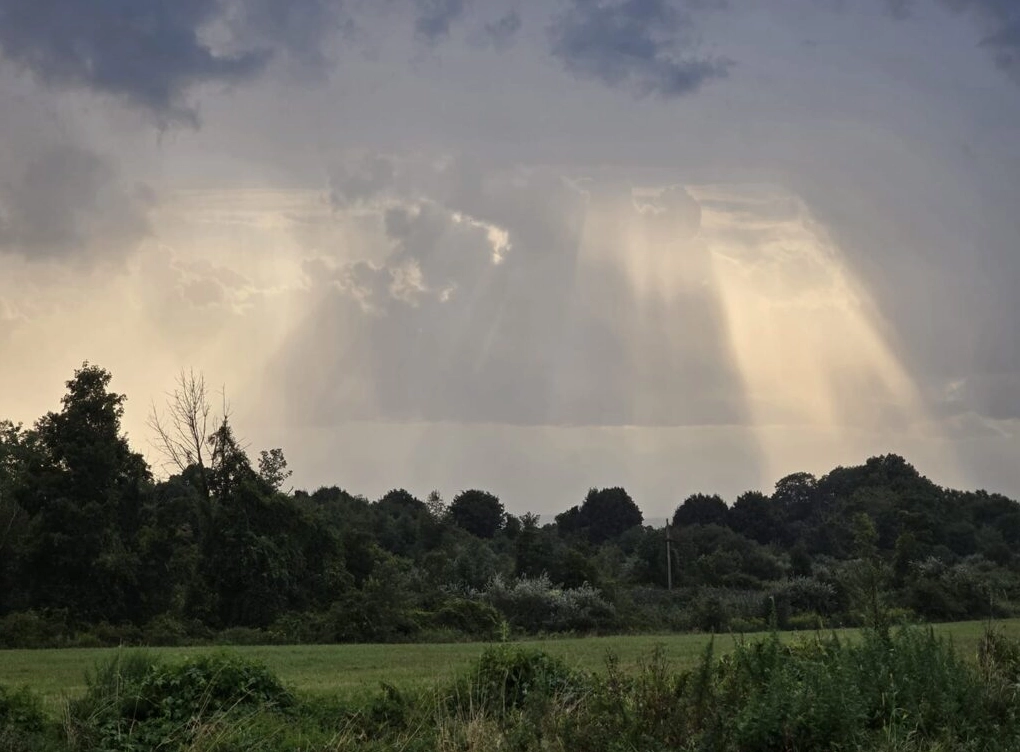 Crepuscular rays appearing dramatically over a landscape