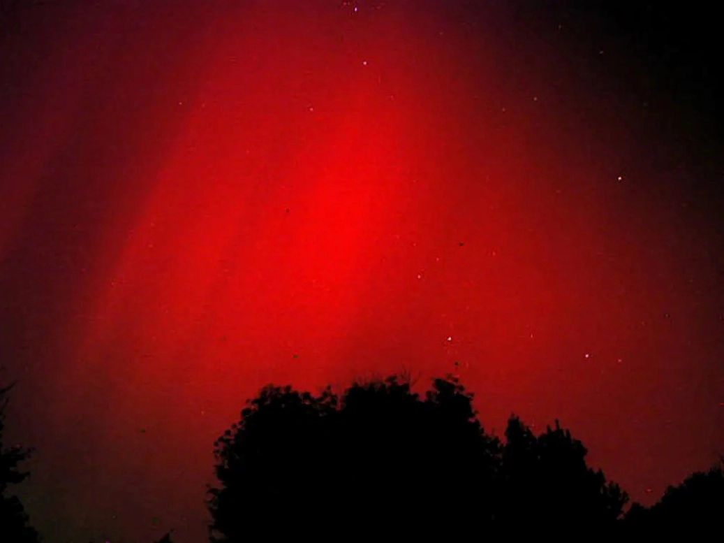Stunning aurora borealis visible over a dark landscape
