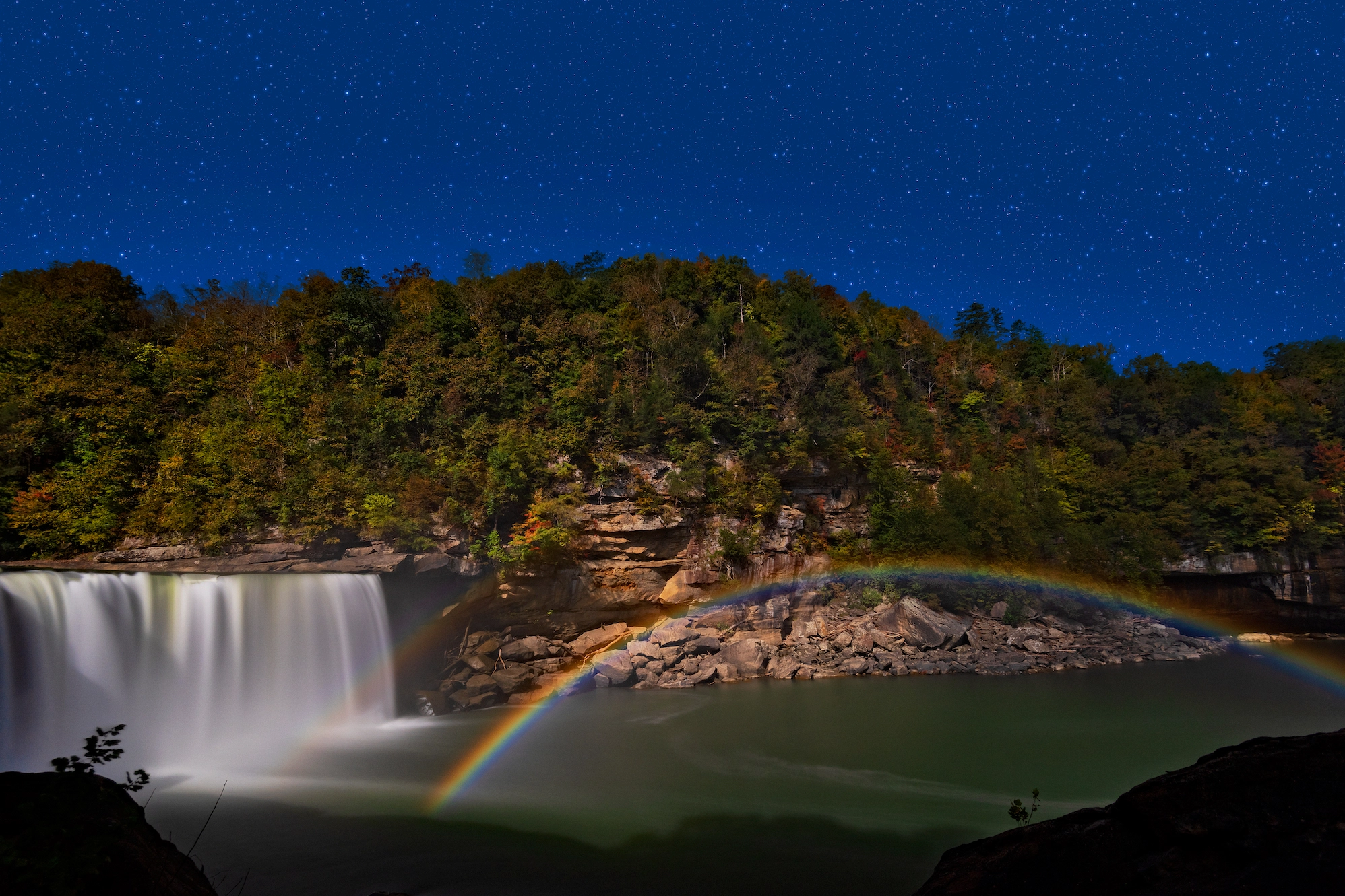 The subtle colors of a moonbow are visible in a long-exposure photograph