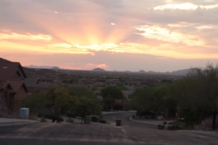 Vivid crepuscular rays stretching across a cloudy sky at sunset