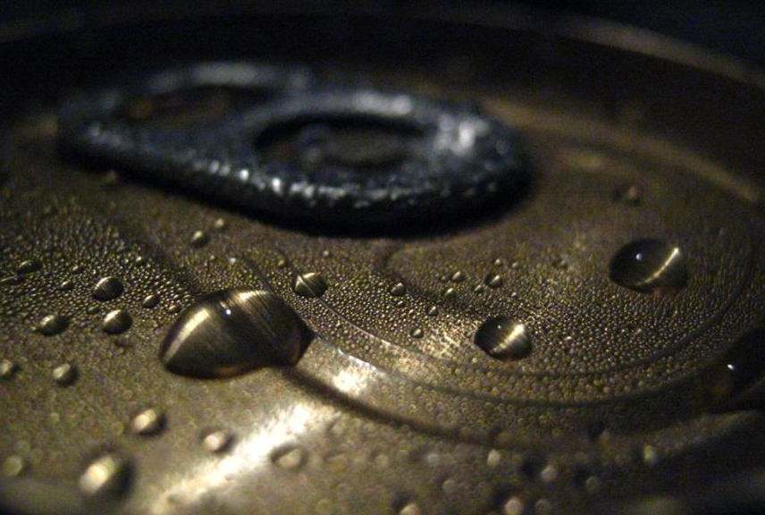 Water condenses on the outside of an aluminum can due to the cooling effect.
